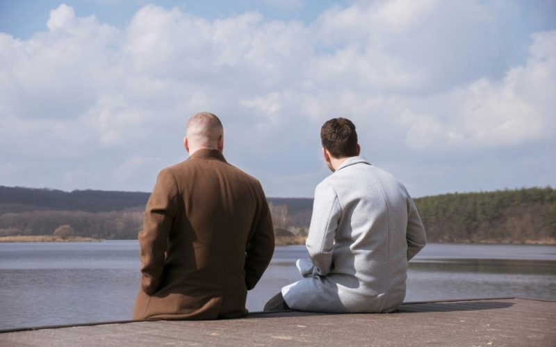Two men siting looking at the view