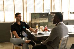 two men sat at a table talking